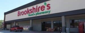 Brookshire's food and pharmacy store exterior with shopping carts and parking lot, showcasing retail and pharmacy services, in a suburban shopping plaza.