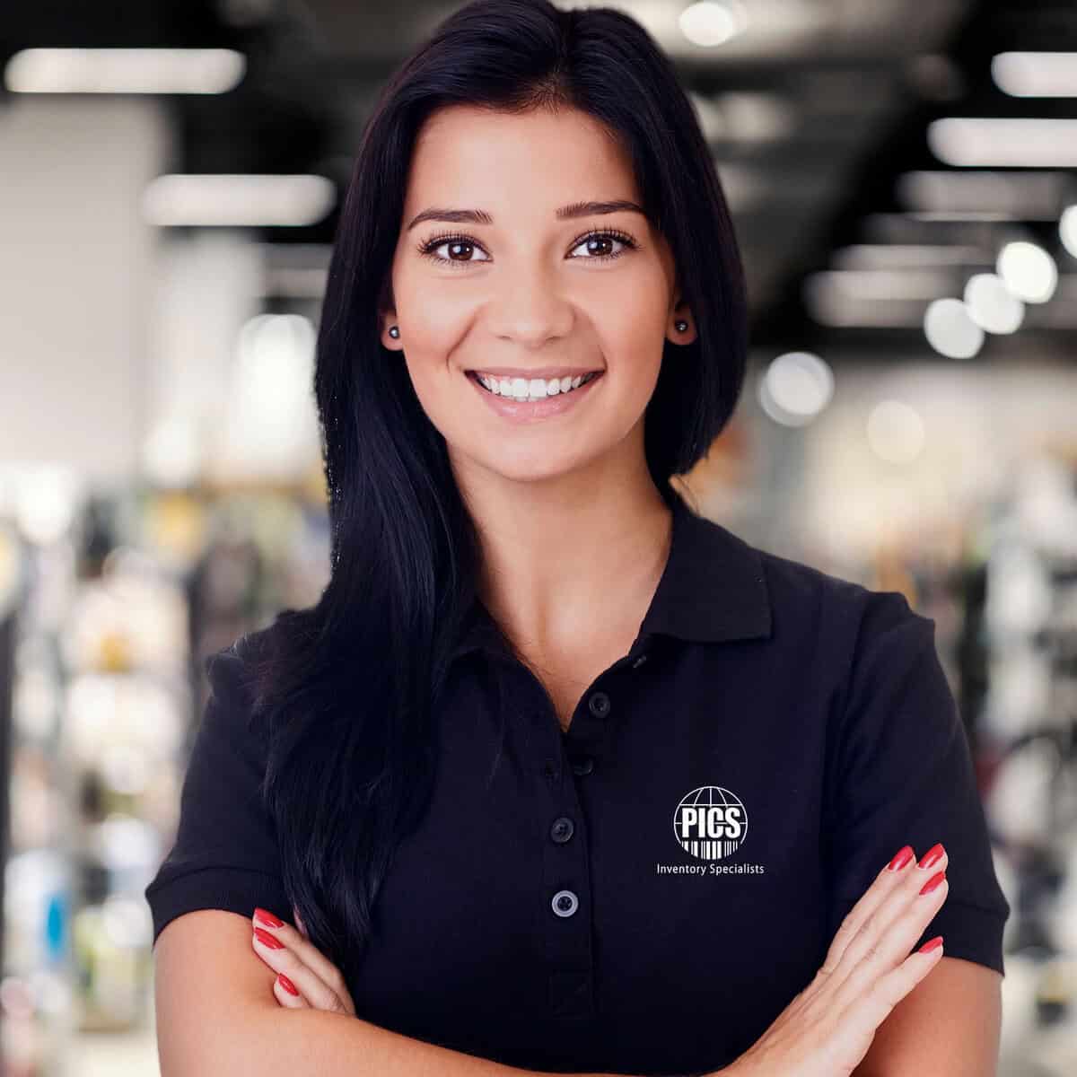 Inventory specialist woman smiling with arms crossed in warehouse setting, professional female inventory expert, logistics, stock management, inventory control, PICS Inventory Specialists.
