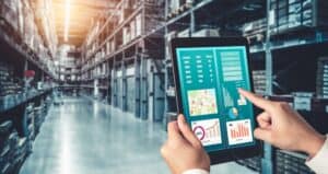 Real-time inventory management using digital tablets in a warehouse setting; inventory specialists optimizing stock with data analytics and technology.
