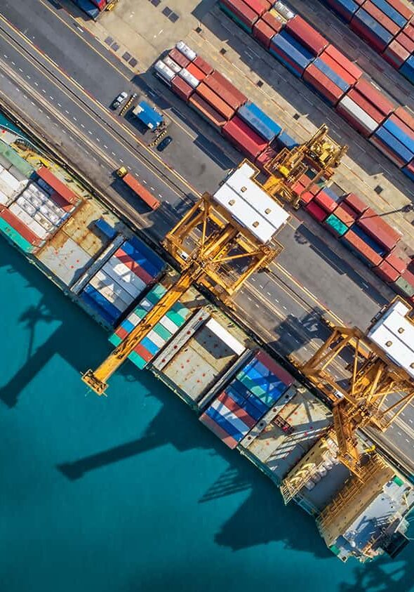 Imported cargo containers at port with cranes and shipping vessels, showcasing logistics, freight handling, and inventory management in international shipping.